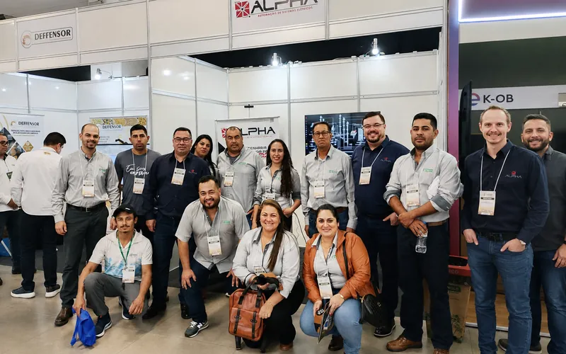 Equipe da Alpha reunida no estande de uma feira do setor