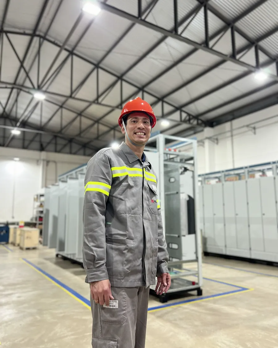 Colaborador da Alpha na fábrica de painéis, entre painéis em montagem